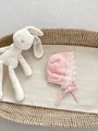Dettaglio della cuffia neonata in cotone rosa con pizzo floreale bianco e lacci - M Taglia Unica / Grande Volant / Rosa