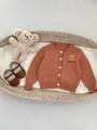 Gebreid babyvestje in steenrood met schattig berenborduursel en witte ronde knopen - 66cm / Bruin