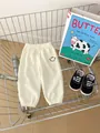 Cremeweiße Kinderhose aus Waffelstrick mit Smiley-Aufdruck und elastischem Bund - 120cm / Aprikose