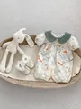 Detail van een babyromper met dierenprint en Peter Pan-kraag in een decoratieve mand - 66CM / Dierenprint Kruippakje