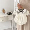 Detalle de pelele para bebé con cuello bordado de flores y lazo negro en algodón beige - Blanco / 66CM