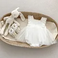 Detalle del pelele de encaje para bebé con bordados florales y falda de tul multicapa - Blanco / 66cm
