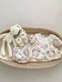 Flat lay of baby girl floral summer outfit with lace collar and matching shoes in a basket - 66cm / Set
