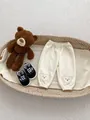 Cream waffle knit baby trousers featuring cute bear embroidery and elasticated cuffs - 120cm / Apricot Bear