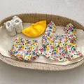 Flat lay of floral baby summer set with sleeveless top, shorts, hat, and lace shoes - 100cm / White Floral
