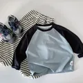 Dettaglio di un set t-shirt a maniche raglan e pantaloni a righe in cotone per bambino - 90cm / Blu