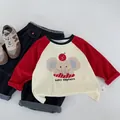 Flat lay of baby elephant cartoon long sleeve tee and dark blue denim jeans with 90 size label - 120cm