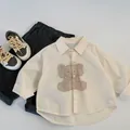 Detailed flat-lay of kids beige cartoon elephant shirt and charcoal casual trousers - 90cm / Beige