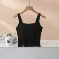 Haut court noir à larges bretelles en coton doux présenté sur un cintre en bois - S / Noir