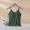 Dark green modal camisole with built-in chest pads on wooden hanger in lifestyle scene - S / Glass Green