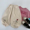 Flat lay detail of kids casual outfit with pink t-shirt, beige joggers and retro sneakers - 90cm / Apricot