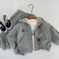 Détail à plat d'un sweat à capuche gris et d'un jogging avec motifs cartoon et t-shirt - 90cm / Gris Chiné