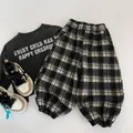 Flat lay of kids' casual outfit with grey slogan sweatshirt and plaid jogger pants - 90 / Black Check