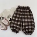 Flat lay of brown checkered toddler pants with elastic waist and gathered cuffs - 90 / Coffee Plaid