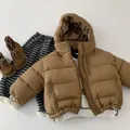 Vue détaillée à plat d'une doudoune à capuche marron pour enfant avec poches et bottes - 90cm / Café Clair