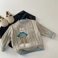 Dettaglio del maglione grigio a trecce con toppa a forma di orso e bordi blu a contrasto - Grigio / 90cm