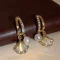 Golden fringe tassel earrings with white pearls and sparkling rhinestone leaf details - E1831 Gold / 925 Silver Needle