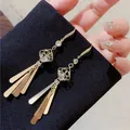 Luxurious gold clover earrings with long metal tassels and crystal accents - E1596 Gold / 925 Silver Needle