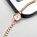 Detailed close-up of rose gold watch with heart links and rhinestone accents - Rose Gold Case White Dial