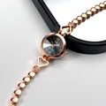 Detail of rose gold watch dial with Roman numerals and heart-shaped crystal bracelet - Rose Gold Case Black Dial