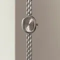 Détail d'une montre vintage ovale argentée avec chiffres romains et bracelet gourmette - Boîtier Argenté Cadran Gris