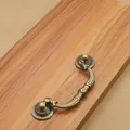 Macro detail of antique bronze cabinet handle with floral carvings on wood background - Hole Distance 96mm / Antique Bronze