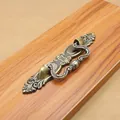 Close-up of vintage bronze zinc alloy furniture handle with floral carving on wood - 64mm / Antique Bronze
