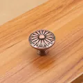 Detail view of antique bronze cabinet knob with embossed floral chrysanthemum pattern - Red Copper - Large
