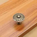Close-up of vintage bronze cabinet knob with sunflower carving on wooden drawer - Bronze - Large
