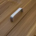 Maniglia per mobili a U in alluminio argento opaco installata su un'anta in legno marrone - 96