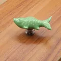 Detail of creative fish-shaped ceramic drawer handle in light green with silver base - Green