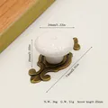 Detailed view of white ceramic knob with embossed flowers and zinc alloy base - Antique Bronze Base White
