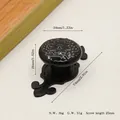 Detail of vintage black cabinet knob with embossed texture and long floral base plate - Matte Black Black
