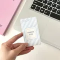 Minimalist blue striped Thank You card held by hand over a desk setup background - Blue