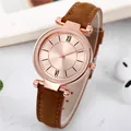 Détail de montre femme or rose avec cadran soleil et bracelet cuir à surpiqûres - Marron