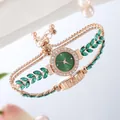 Macro detail of rose gold quartz watch with emerald green dial and leaf-shaped bracelet - Green