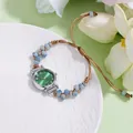 Dettaglio dell'orologio al quarzo con cinturino intrecciato e quadrante verde solare - Perline Blu Cinturino Caffè Scuro Quadrante Verde Soleil