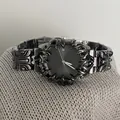 Détail macro d'une montre gothique en métal avec lunette épine et guichet de date - Noir