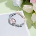 Dettaglio orologio da donna con cinturino intrecciato, quadrante rosa e perle blu - Perline Blu Cinturino Caffè Chiaro Quadrante Rosa Soleil
