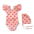 Flat lay of pink polka dot kids swimsuit with ruffled shoulders and matching swimming cap - Pink Red Polka Dot Cross Strap