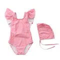 Flat lay of pink striped toddler swimsuit with ruffle shoulders and matching swim cap - Pink White Grid Cross Strap