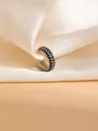 Nahaufnahme der silbernen Ohrmanschette mit drei Reihen schwarzer Zirkonia auf Seide - C-Form Pave Ohrmanschette / Silber Schwarz