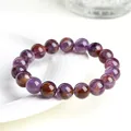 Natural purple ghost crystal bracelet with polished amethyst beads on a white tray - 8mm Purple Phantom Crystal Bracelet