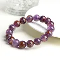 Polished natural purple phantom crystal bead bracelet with red inclusions on a white tray - 10mm Purple Phantom Crystal Bracelet