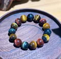 Detailed close-up of natural red, blue and gold tiger eye beads on a wooden tray - 14mm / Red Blue Yellow Tiger Eye