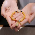 Close-up of beaded jade bracelet with yellow pumpkin beads and a small gourd pendant - Yellow Round Bead with Gourd Pendant