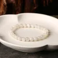 Natürliches weißes Mondstein-Armband mit glatten runden Perlen auf einer Keramikschale - 7mm Weißer Mondstein