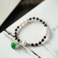 Close-up of garnet beads, freshwater pearls, and an emerald green carved jade pendant - Wine Red Garnet Freshwater Pearl Dry Green Jade Lotus