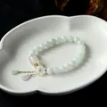 Detailaufnahme von Naturjade-Perlenarmband mit 14K Gold-Muschelblume und Jade-Anhängern - Hellgrüne Runde Perlen Muschelblume Jade Wassertropfen Stil