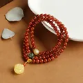 Macro view of multi-strand red agate bracelet with carved amber rose charm and gold spacers - Triple Wrap / Flame Red Style (A3)